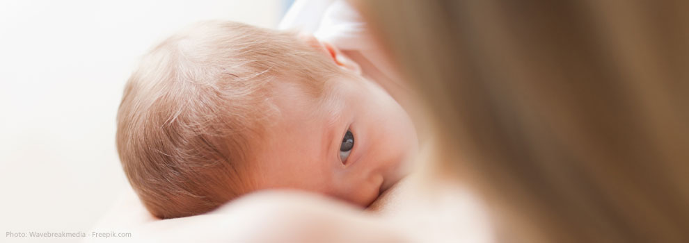 Baby wird gestillt und hält Blickkontakt zur Mutter